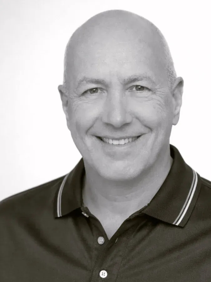 Smiling bald middle-aged man in polo shirt headshot